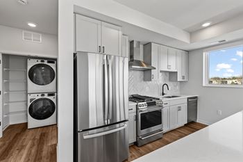 a renovated kitchen with white cabinets and stainless steel appliances